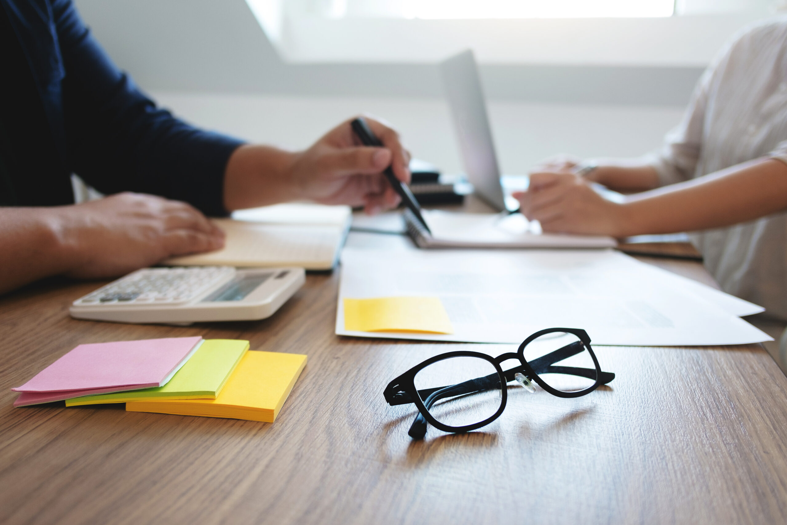 Two adult people working together with documents in library. Education concept.