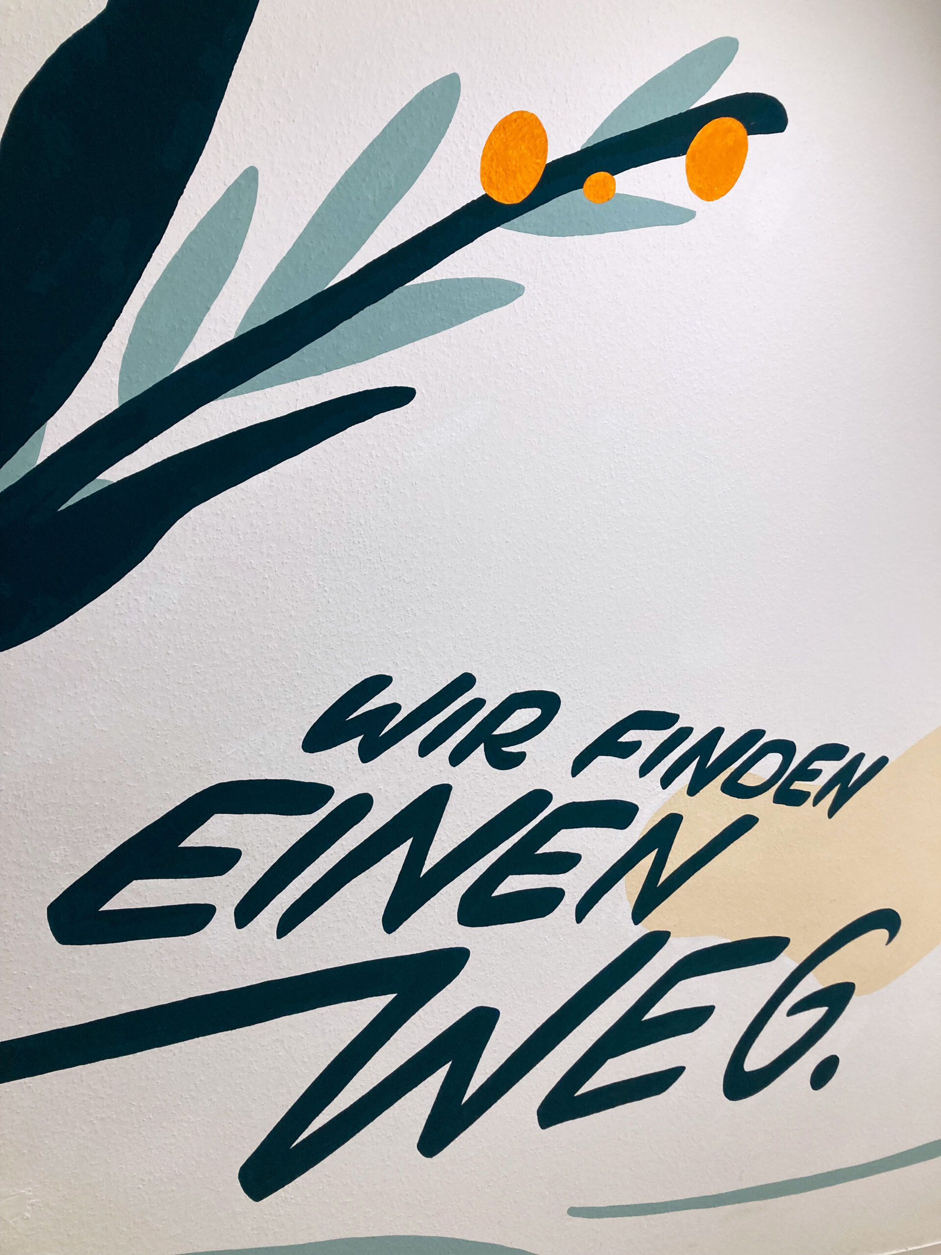 Wandmalerei mit stilisiertem Zweig und orangefarbenen Beeren sowie dem Schriftzug 'WIR FINDEN EINEN WEG'