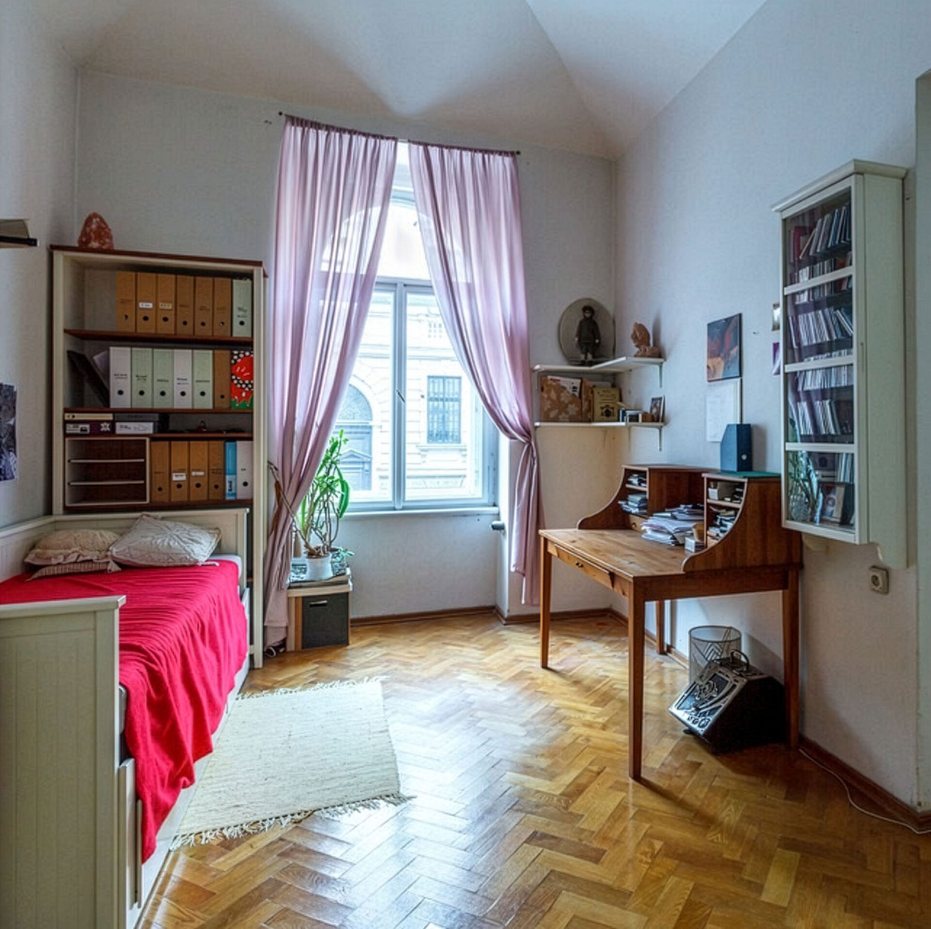WG-Zimmer mit Bett, Schreibtisch, Regal und Fenster mit rosa Vorhängen