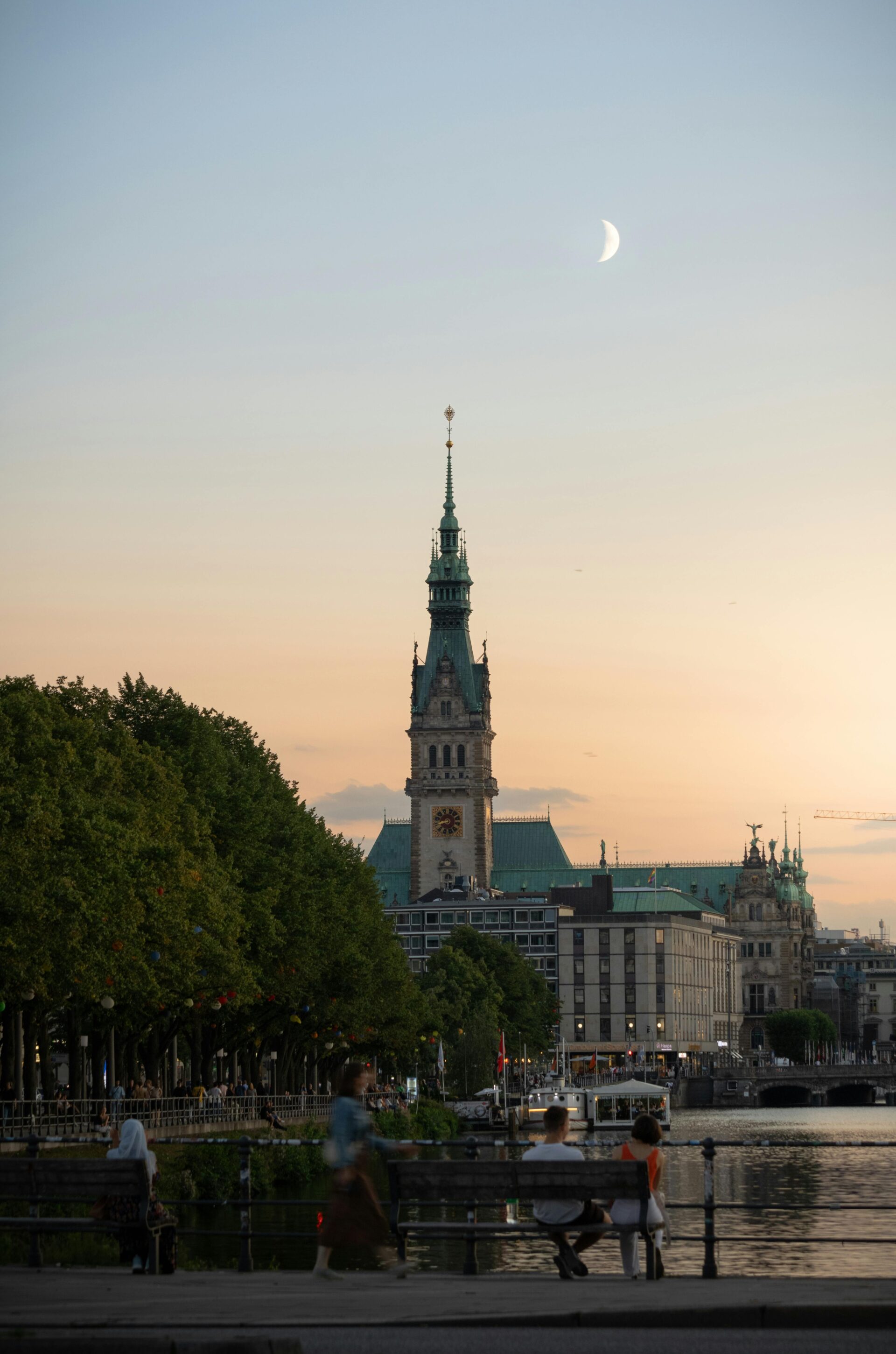Jungfernstieg  bei Abenddämmerung mit sichtbarem Halbmond am Himmel